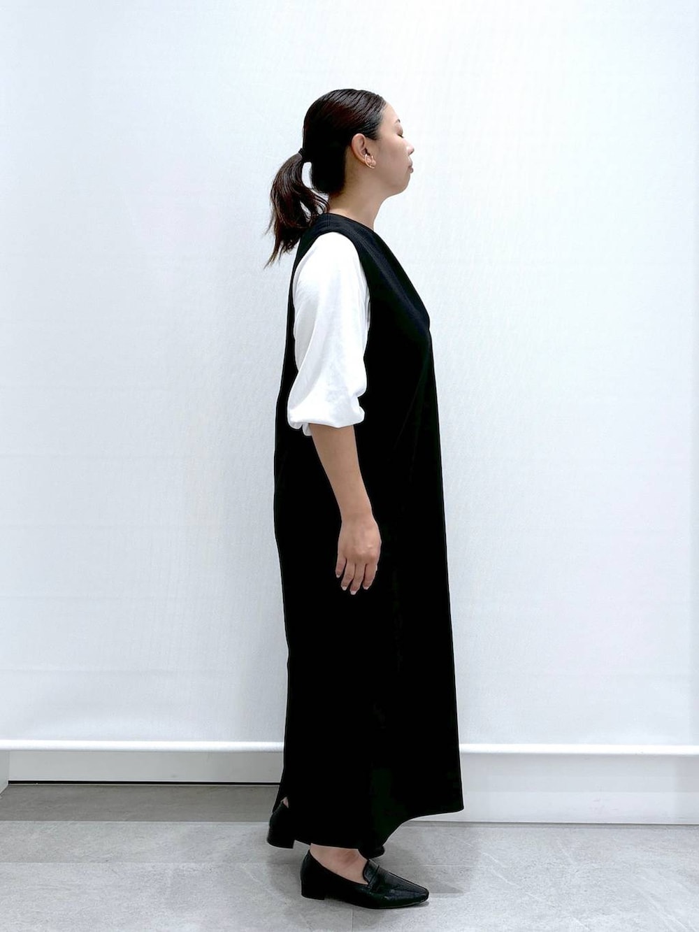 ブラック系のジャンパースカート、ホワイト系のTシャツ/カットソーを着用したレディースの夏コーディネートの5枚目の写真