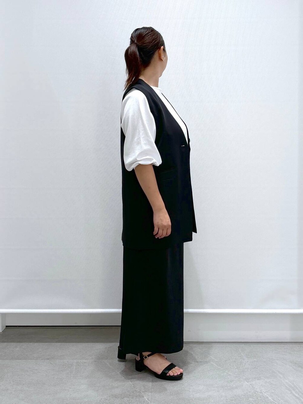 ブラック系のトートバッグ、ブラック系のサンダル、ブラック系のスカートを着用したレディースの秋コーディネートの6枚目の写真