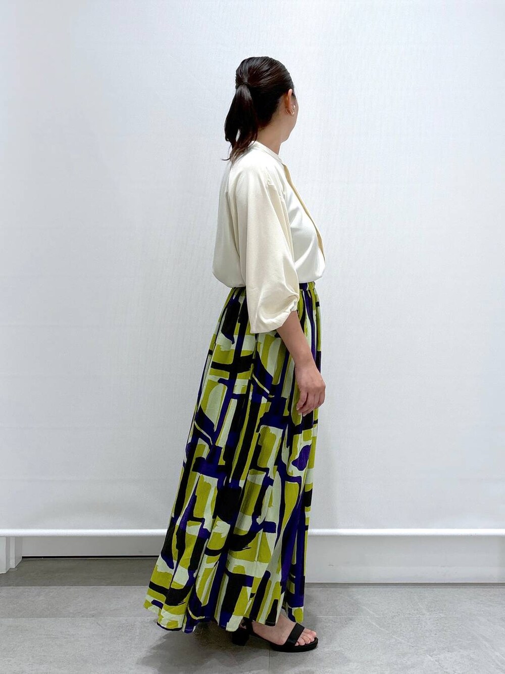 ブラック系のショルダーバッグ、ブラック系のサンダル、ホワイト系のシャツ/ブラウスを着用したレディースの夏コーディネートの5枚目の写真