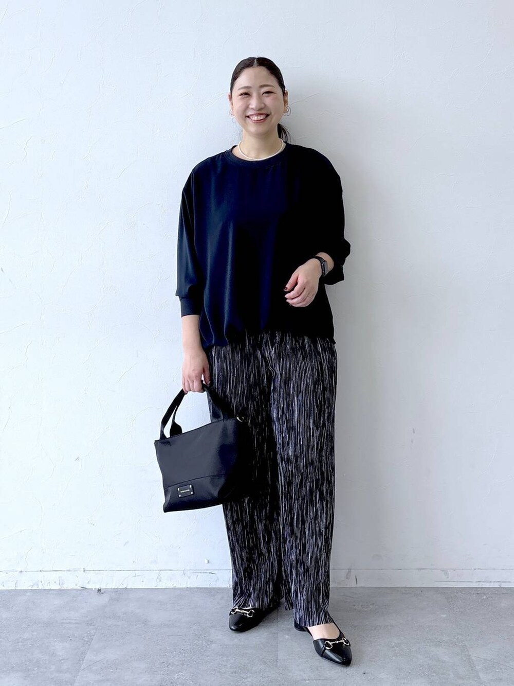 ブラック系のトートバッグ、ブラック系のその他パンツ、ブラック系のパンプスを着用したレディースの冬コーディネートの2枚目の写真