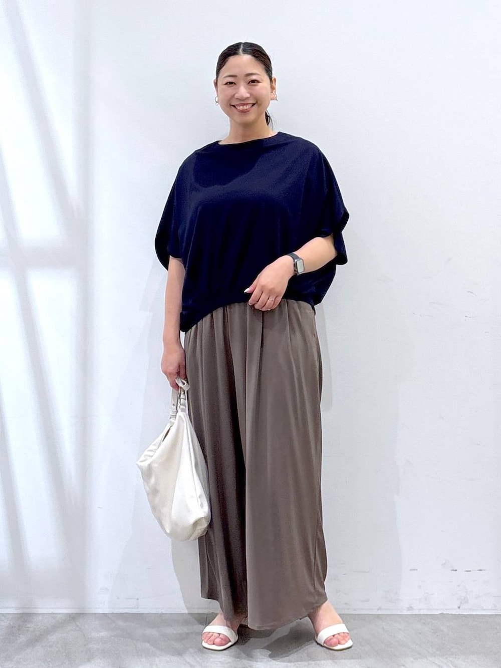 ホワイト系のハンドバッグ、グリーン系のその他パンツ、ブルー系のTシャツ/カットソーを着用したレディースの夏コーディネートの2枚目の写真