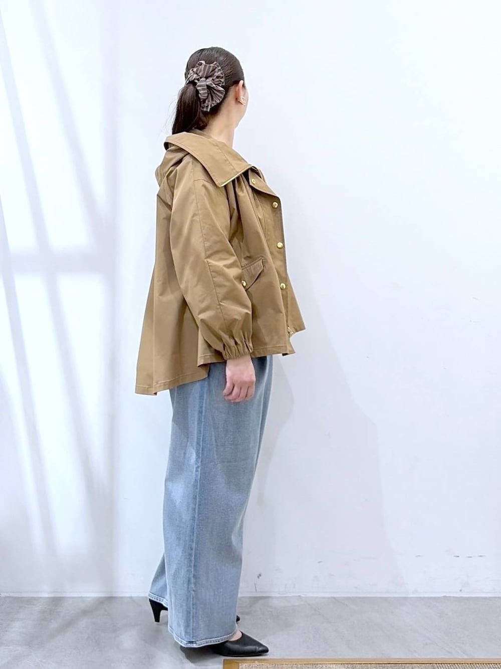 ブラック系のトートバッグ、ホワイト系のニット/セーター、ブルー系のデニムパンツを着用したレディースの春コーディネートの5枚目の写真