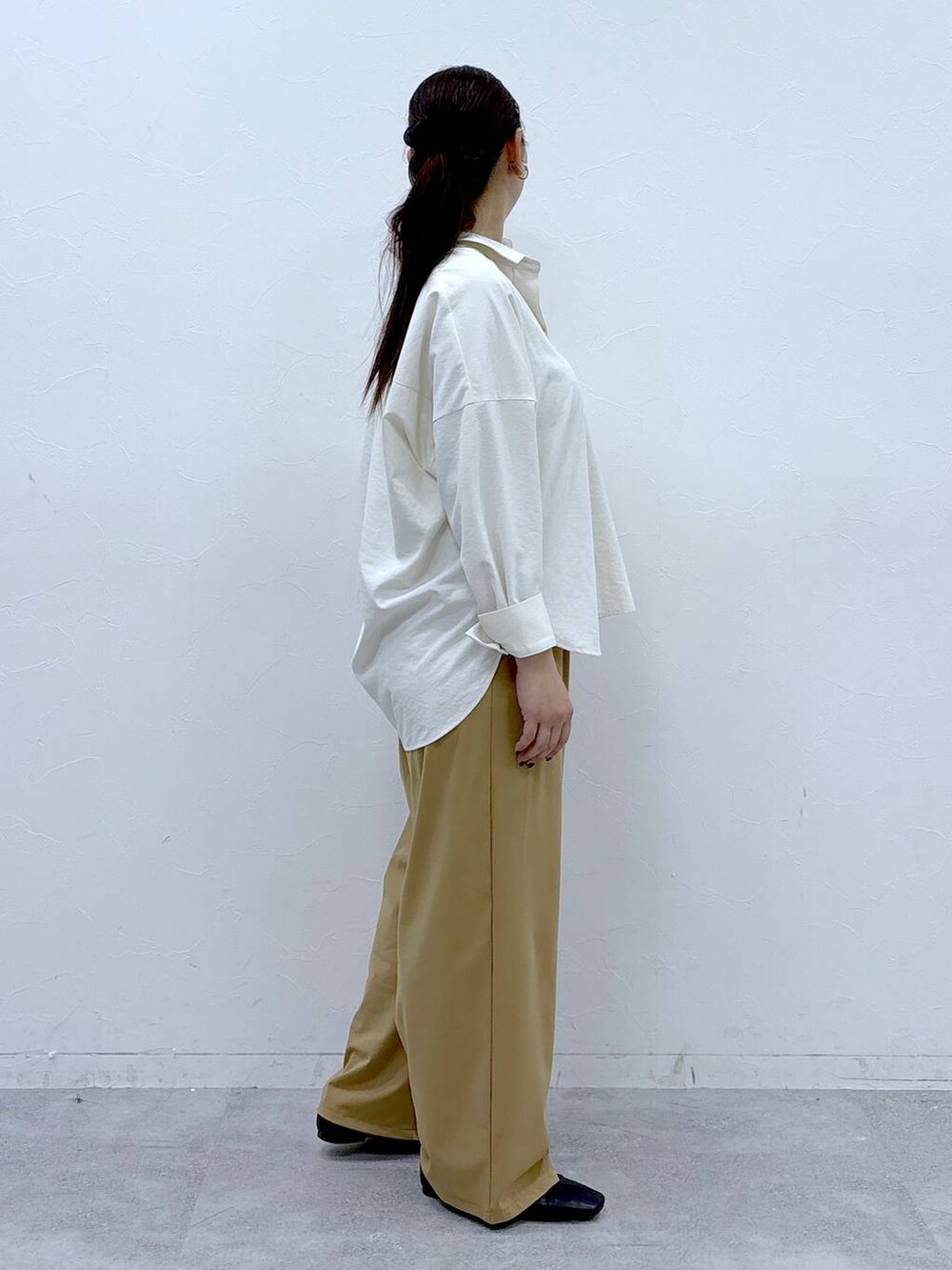 ブラック系のハンドバッグ、ブラック系のパンプス、ホワイト系のシャツ/ブラウスを着用したレディースの冬コーディネートの5枚目の写真