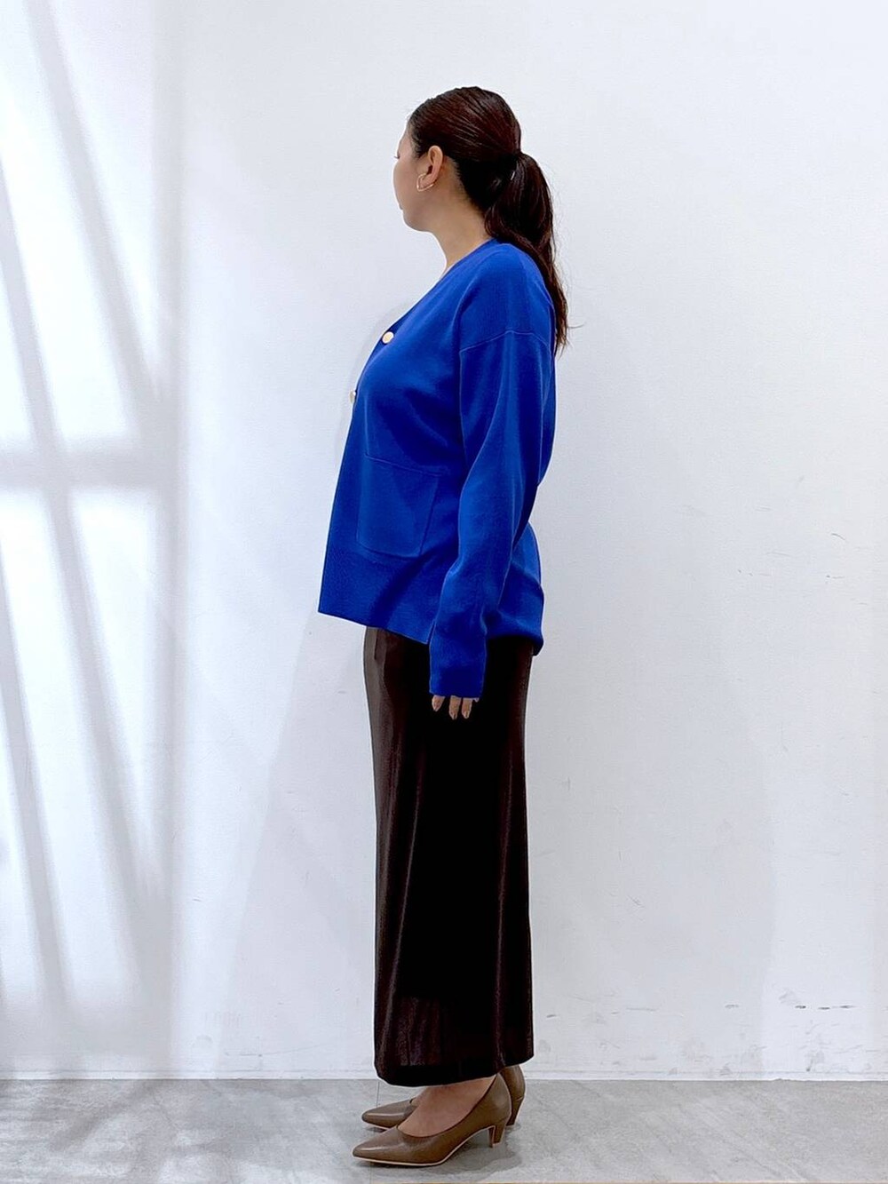 ブラウン系のパンプス、ブルー系のカーディガン/ボレロ、ブラック系のタンクトップを着用したレディースの秋コーディネートの3枚目の写真