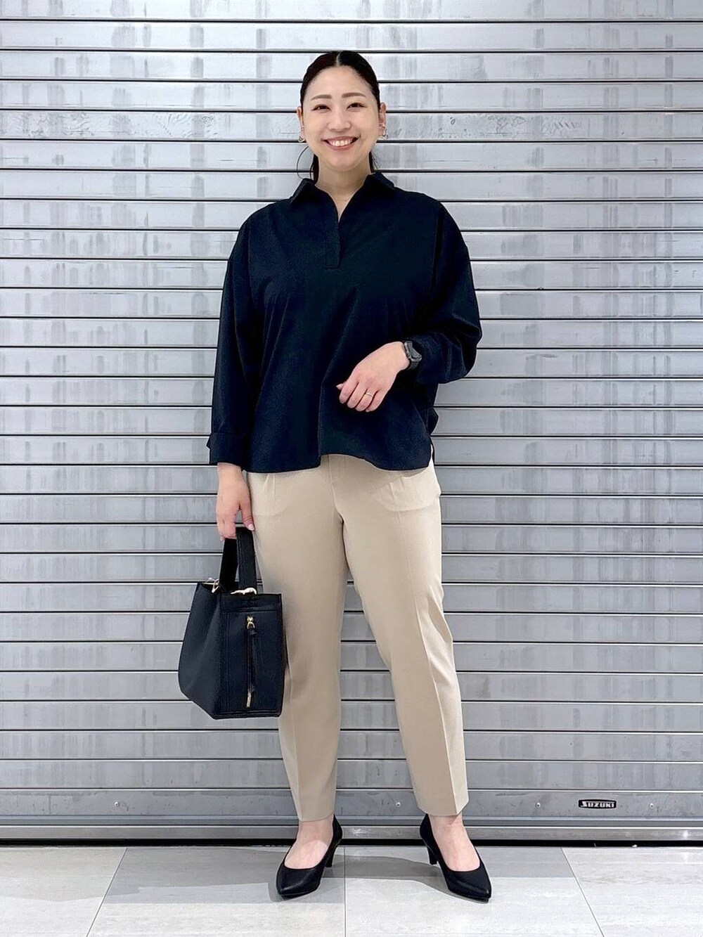 ブラック系のパンプス、ブルー系のシャツ/ブラウス、ブラック系のハンドバッグを着用したレディースの春コーディネートの2枚目の写真