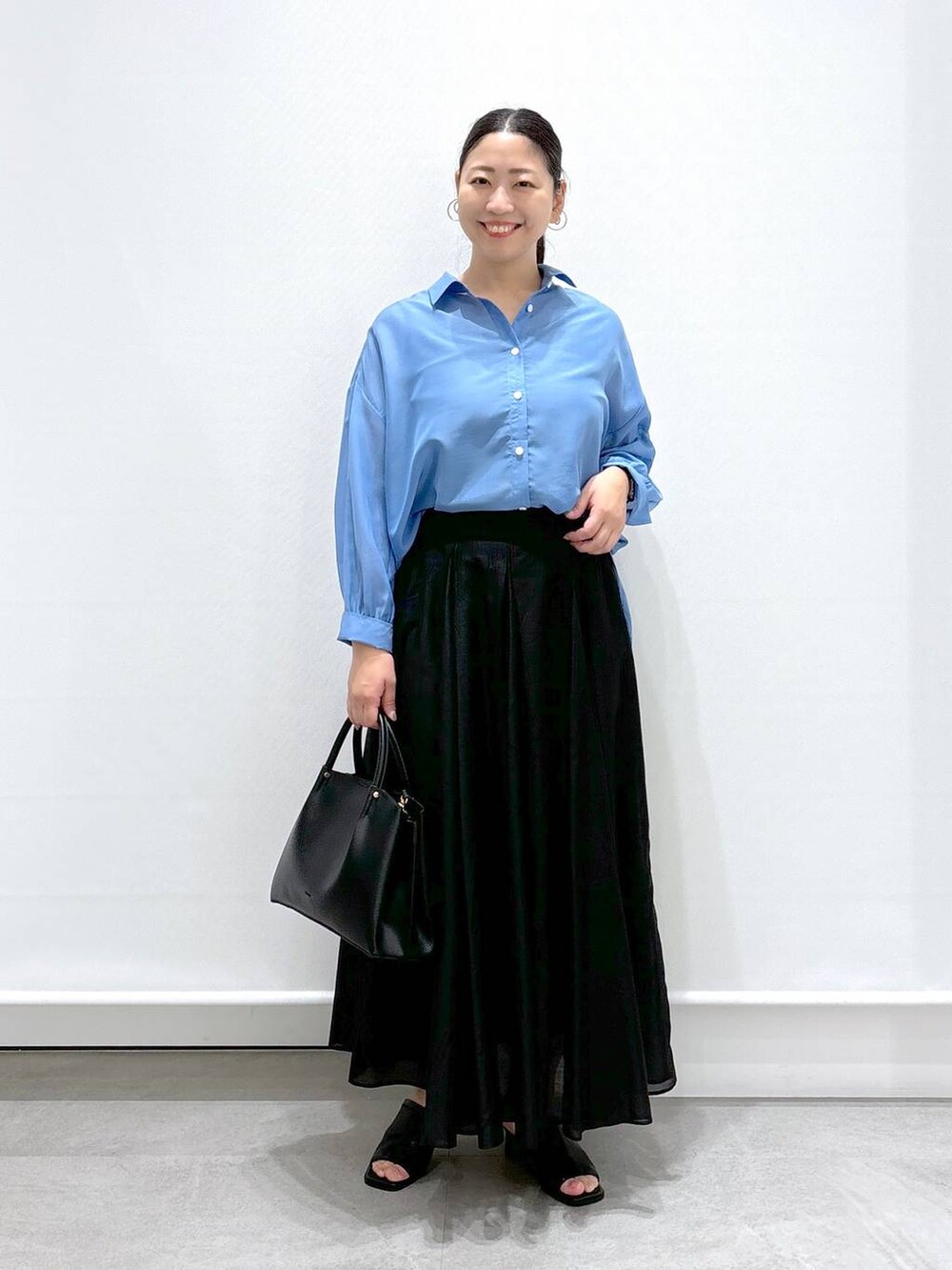 ブラック系のサンダル、ブラック系のショルダーバッグ、ブラック系のスカートを着用したレディースの夏コーディネートの2枚目の写真