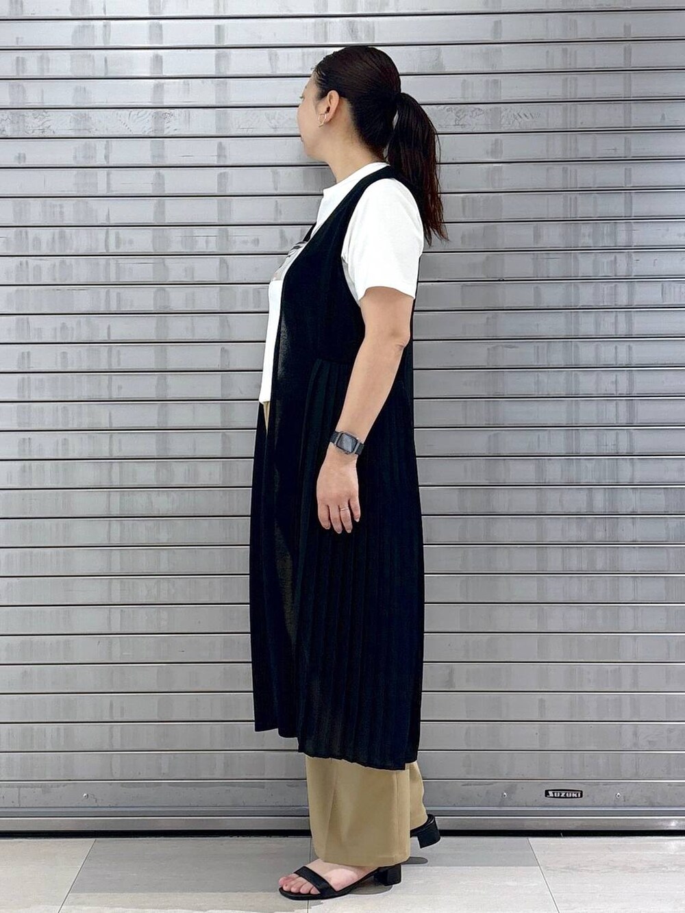 ブラック系のハンドバッグ、ホワイト系のTシャツ/カットソー、ブラウン系のその他パンツを着用したレディースの春コーディネートの3枚目の写真