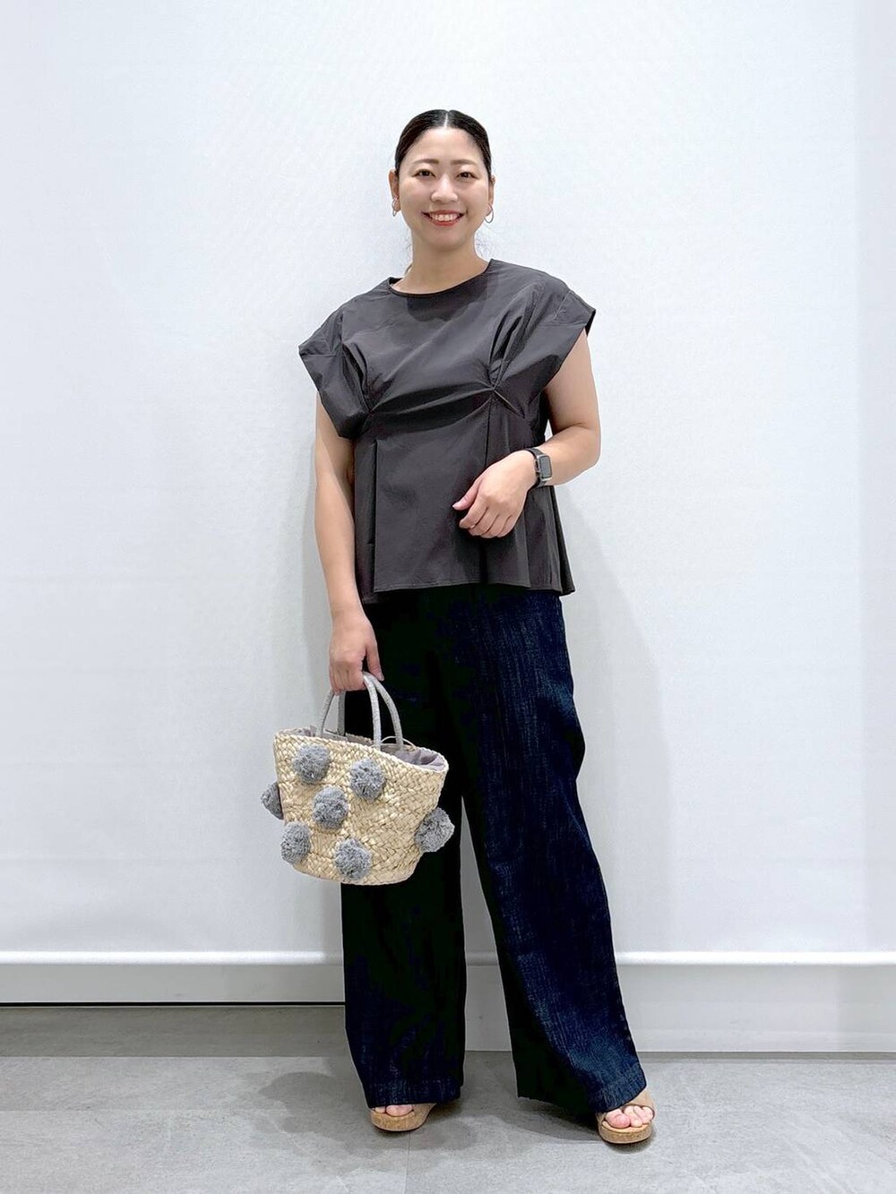 ブルー系のデニムパンツ、ベージュ系のサンダル、グレー系のシャツ/ブラウスを着用したレディースの夏コーディネートの2枚目の写真