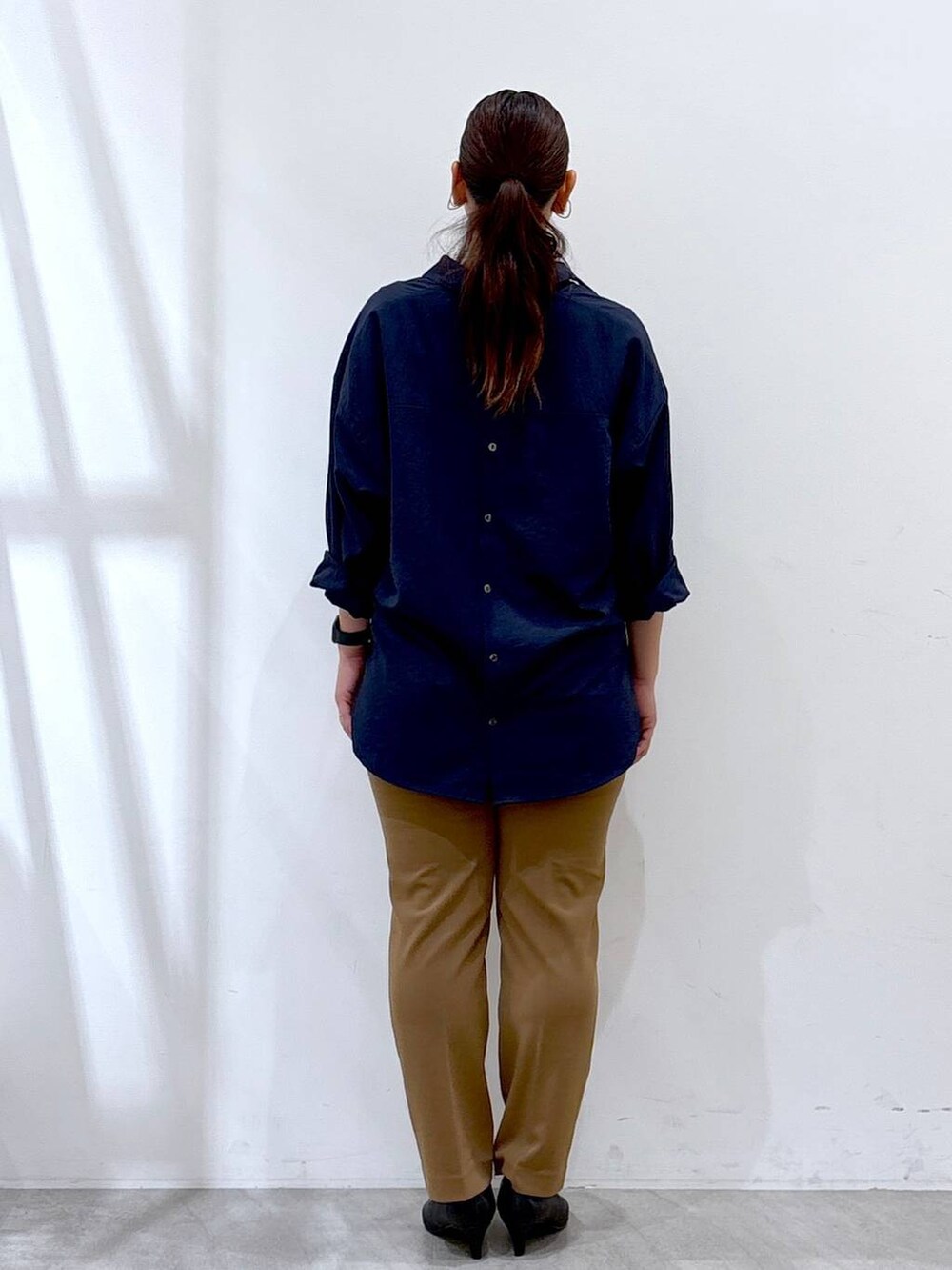 ブラック系のハンドバッグ、ブルー系のシャツ/ブラウス、イエロー系のその他パンツを着用したレディースの秋コーディネートの3枚目の写真