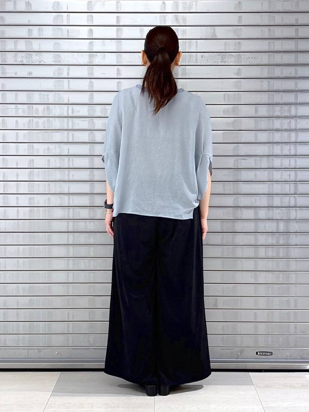 ブラック系のハンドバッグ、ブルー系のTシャツ/カットソー、ブラック系のその他パンツを着用したレディースの春コーディネートの4枚目の写真