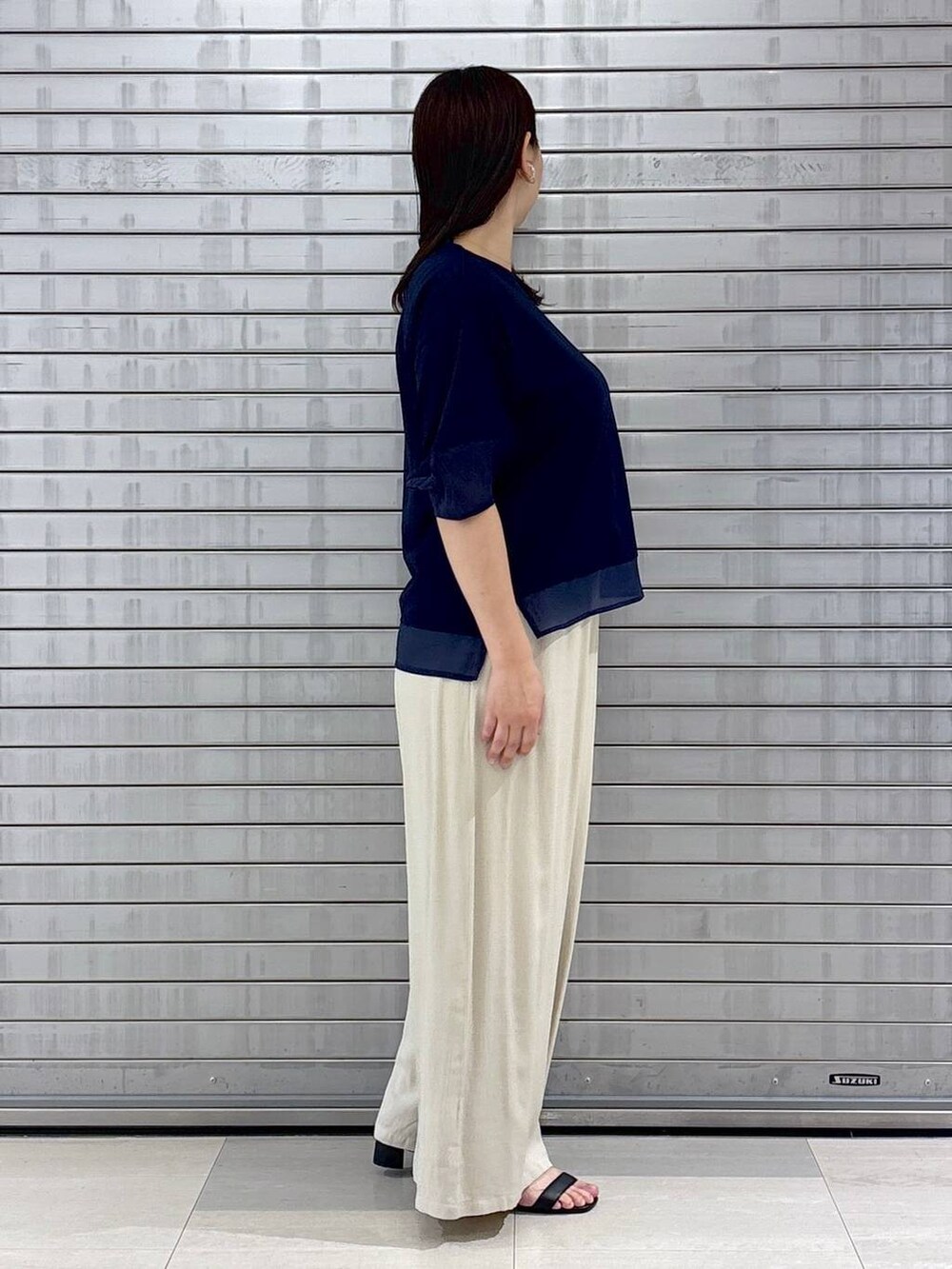 ブラック系のハンドバッグ、ブルー系のTシャツ/カットソー、ベージュ系のその他パンツを着用したレディースの春コーディネートの5枚目の写真