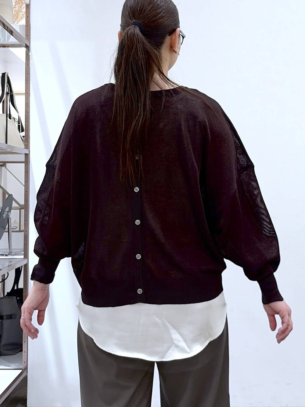 ブラック系のハンドバッグ、グリーン系のその他パンツ、ホワイト系のタンクトップを着用したレディースの春コーディネートの7枚目の写真