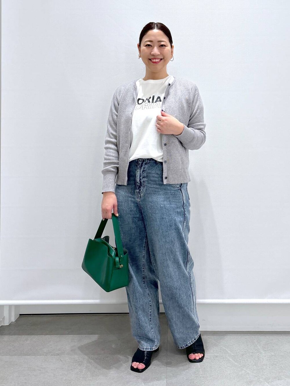 グレー系のカーディガン/ボレロ、ブルー系のデニムパンツ、ブラック系のサンダルを着用したレディースの春コーディネートの2枚目の写真