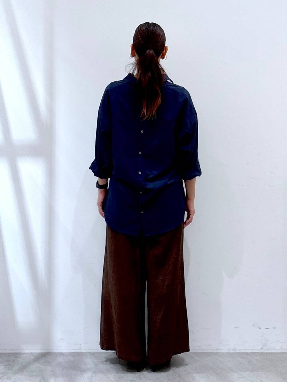 ブラック系のパンプス、ブラウン系のその他パンツ、ブルー系のシャツ/ブラウスを着用したレディースの秋コーディネートの4枚目の写真