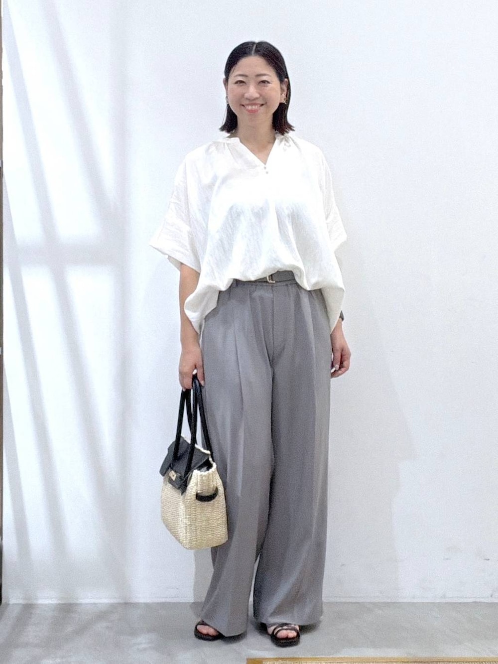 グレー系のその他パンツ、ホワイト系のシャツ/ブラウス、ブラック系のサンダルを着用したレディースの夏コーディネートの2枚目の写真