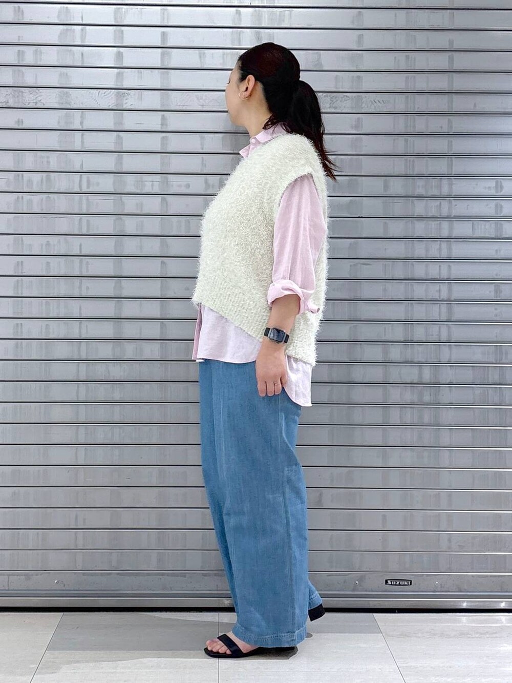 ピンク系のシャツ/ブラウス、ホワイト系のベスト、ブラック系のハンドバッグを着用したレディースの春コーディネートの3枚目の写真