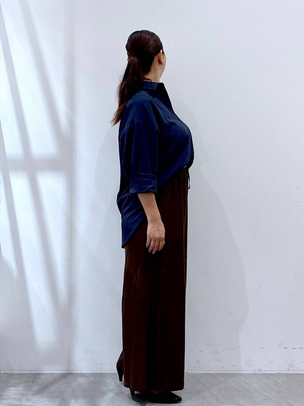 ブラック系のパンプス、ブラウン系のその他パンツ、ブルー系のシャツ/ブラウスを着用したレディースの秋コーディネートの5枚目の写真