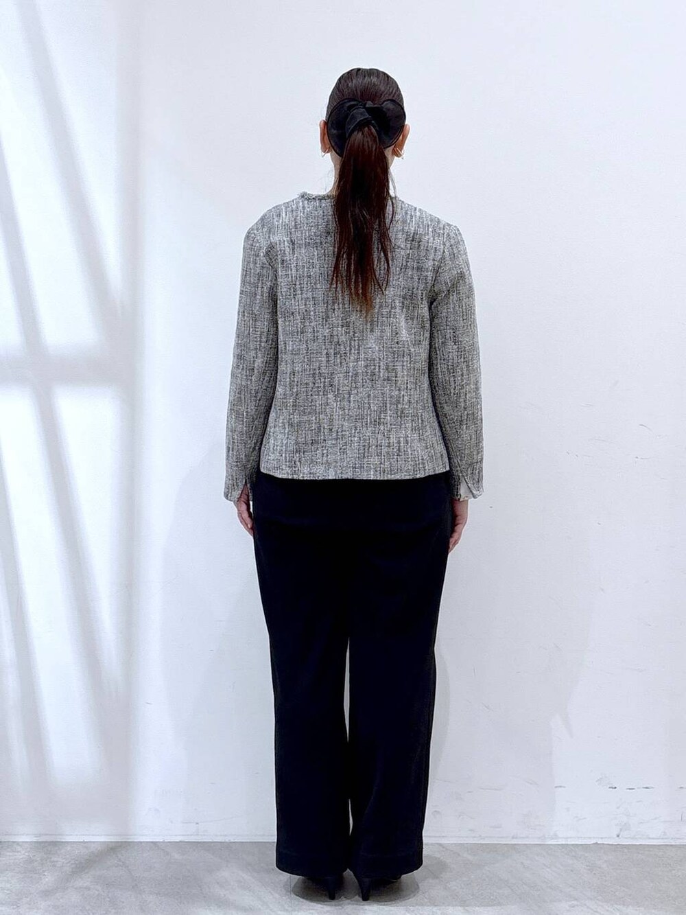 ブラック系のハンドバッグ、ブラック系のその他パンツ、ブラック系のノーカラージャケットを着用したレディースの冬コーディネートの4枚目の写真