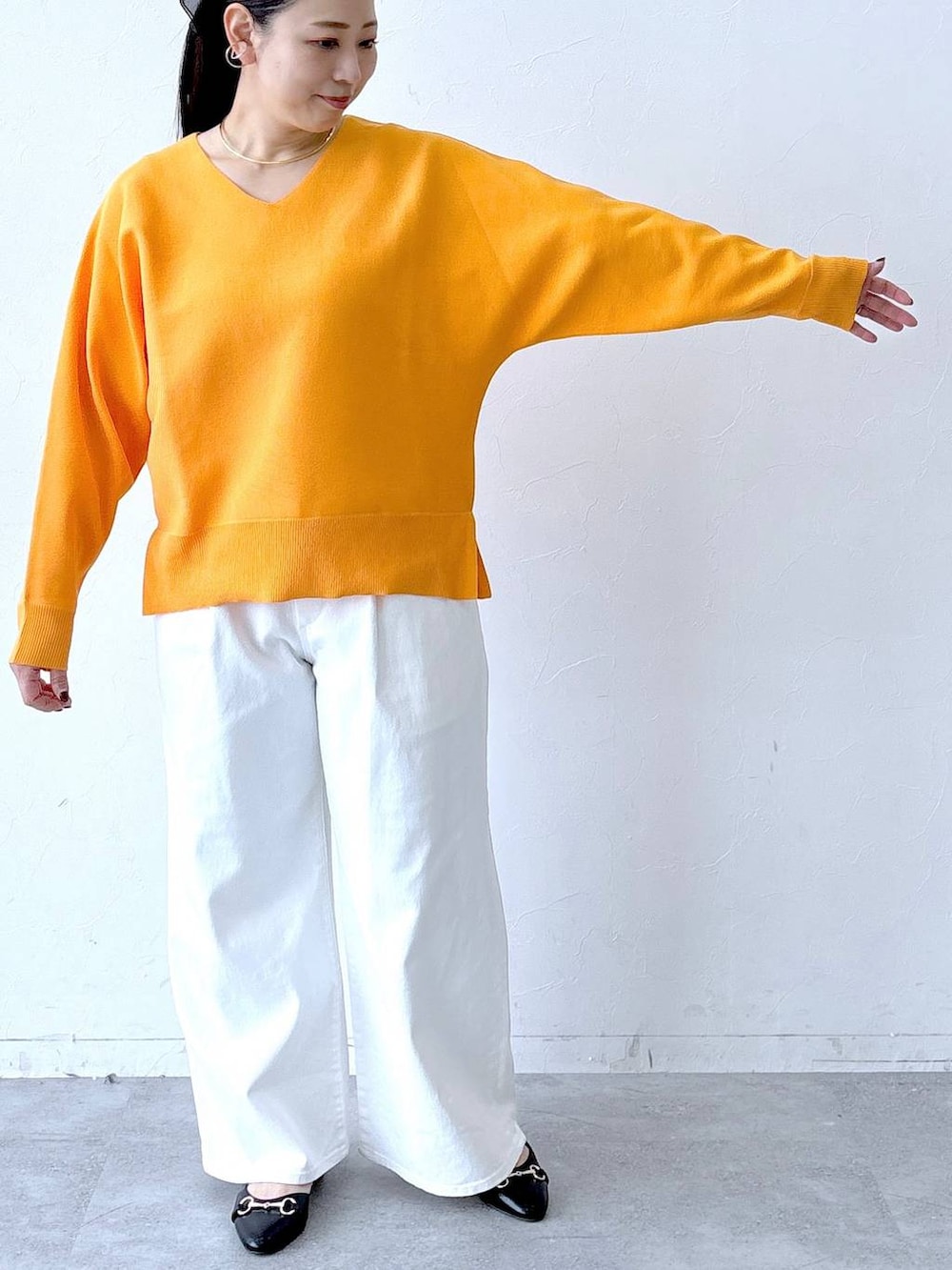 ホワイト系のデニムパンツ、ブラック系のパンプス、ブラック系のトートバッグを着用したレディースの春コーディネートの6枚目の写真