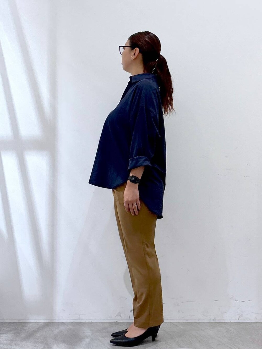 ブラック系のハンドバッグ、ブルー系のシャツ/ブラウス、イエロー系のその他パンツを着用したレディースの秋コーディネートの2枚目の写真