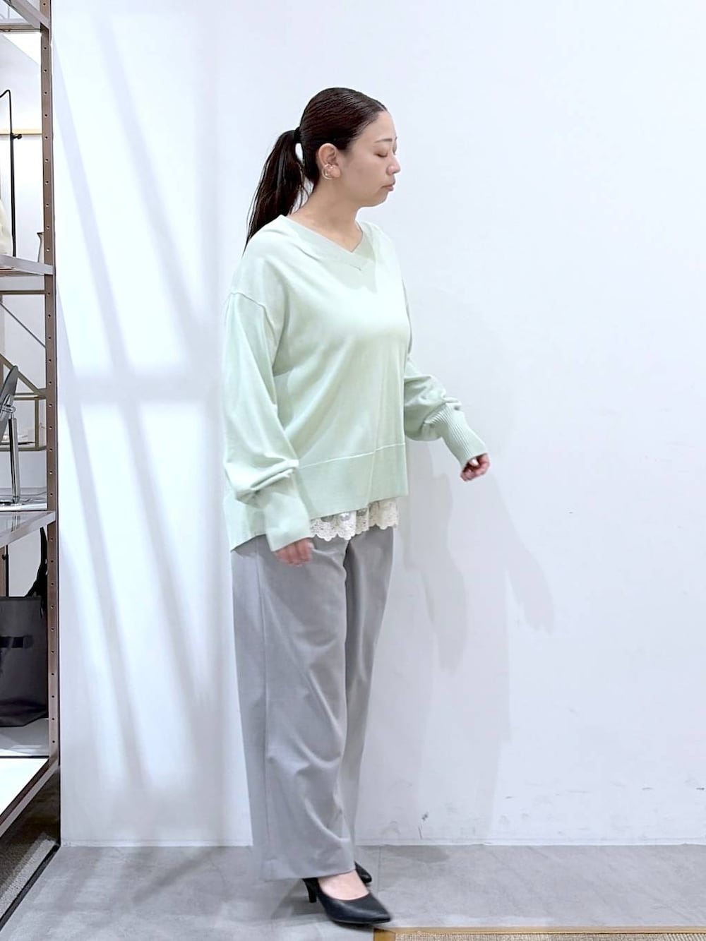 ホワイト系のタンクトップ、ブラック系のハンドバッグ、グレー系のその他パンツを着用したレディースの春コーディネートの6枚目の写真