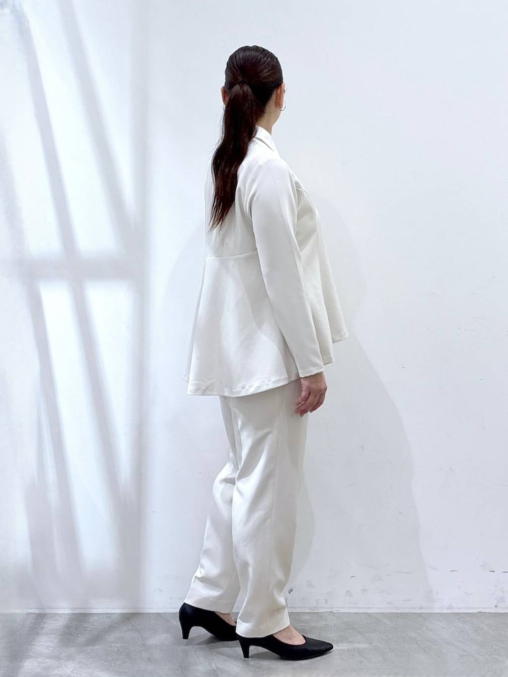 ブラック系のハンドバッグ、ホワイト系のシャツ/ブラウス、ホワイト系のスラックスを着用したレディースの春コーディネートの5枚目の写真
