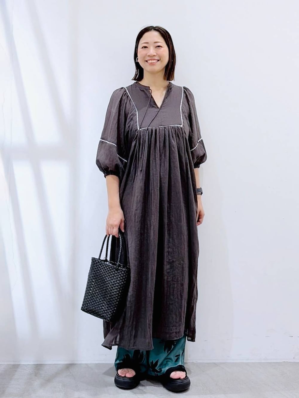 グリーン系のその他パンツ、ブラック系のかごバッグ、グレー系のワンピースを着用したレディースの夏コーディネートの2枚目の写真