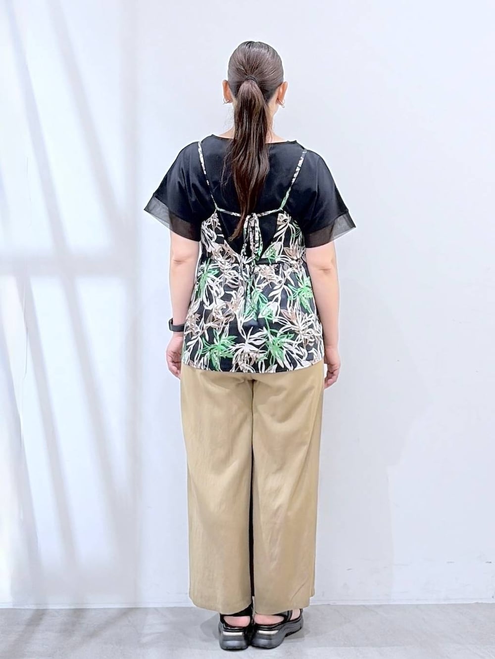 ブラック系のトートバッグ、ベージュ系のその他パンツ、ブルー系のキャミソールを着用したレディースの春コーディネートの4枚目の写真