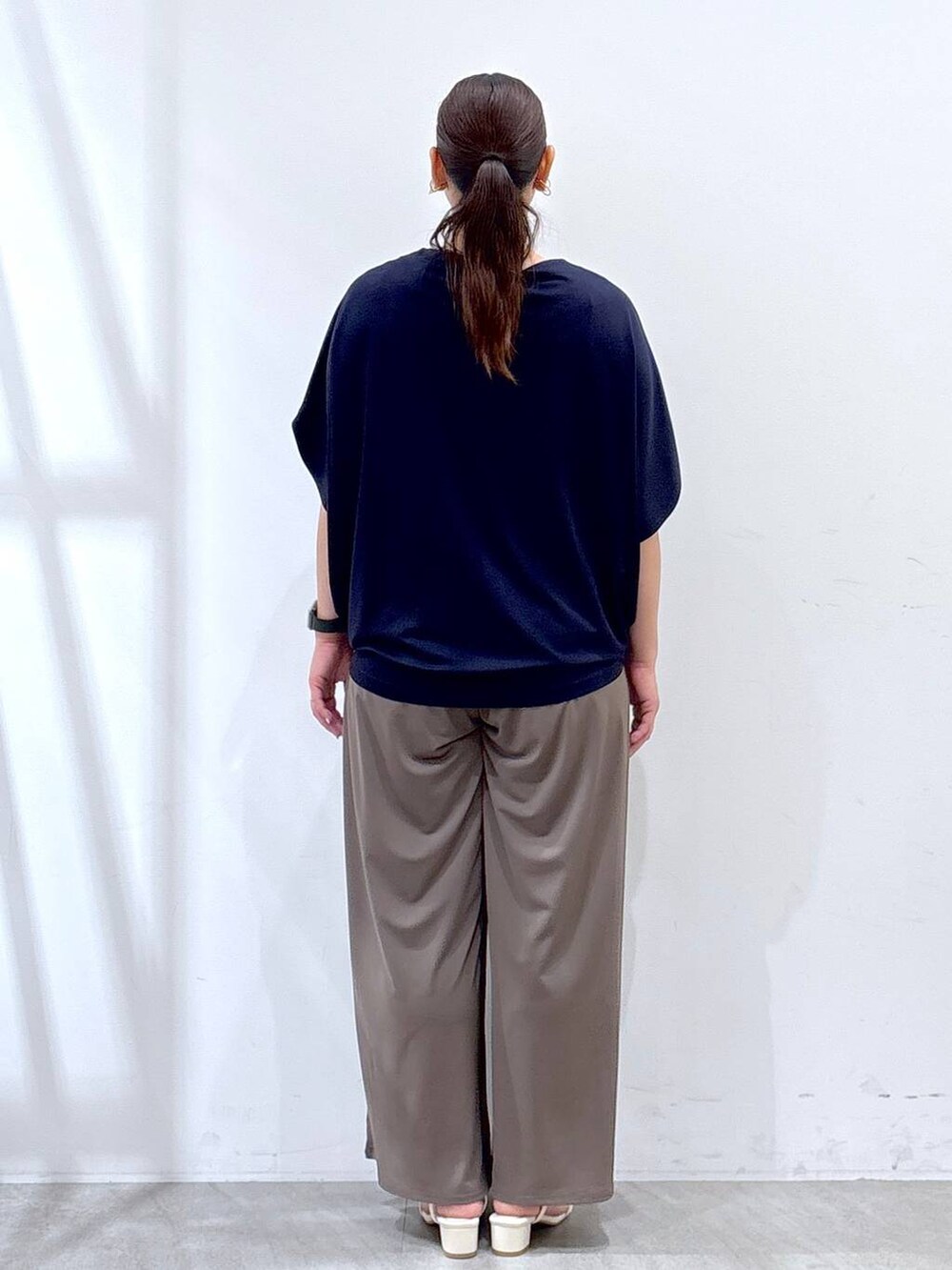 ホワイト系のハンドバッグ、グリーン系のその他パンツ、ブルー系のTシャツ/カットソーを着用したレディースの夏コーディネートの4枚目の写真