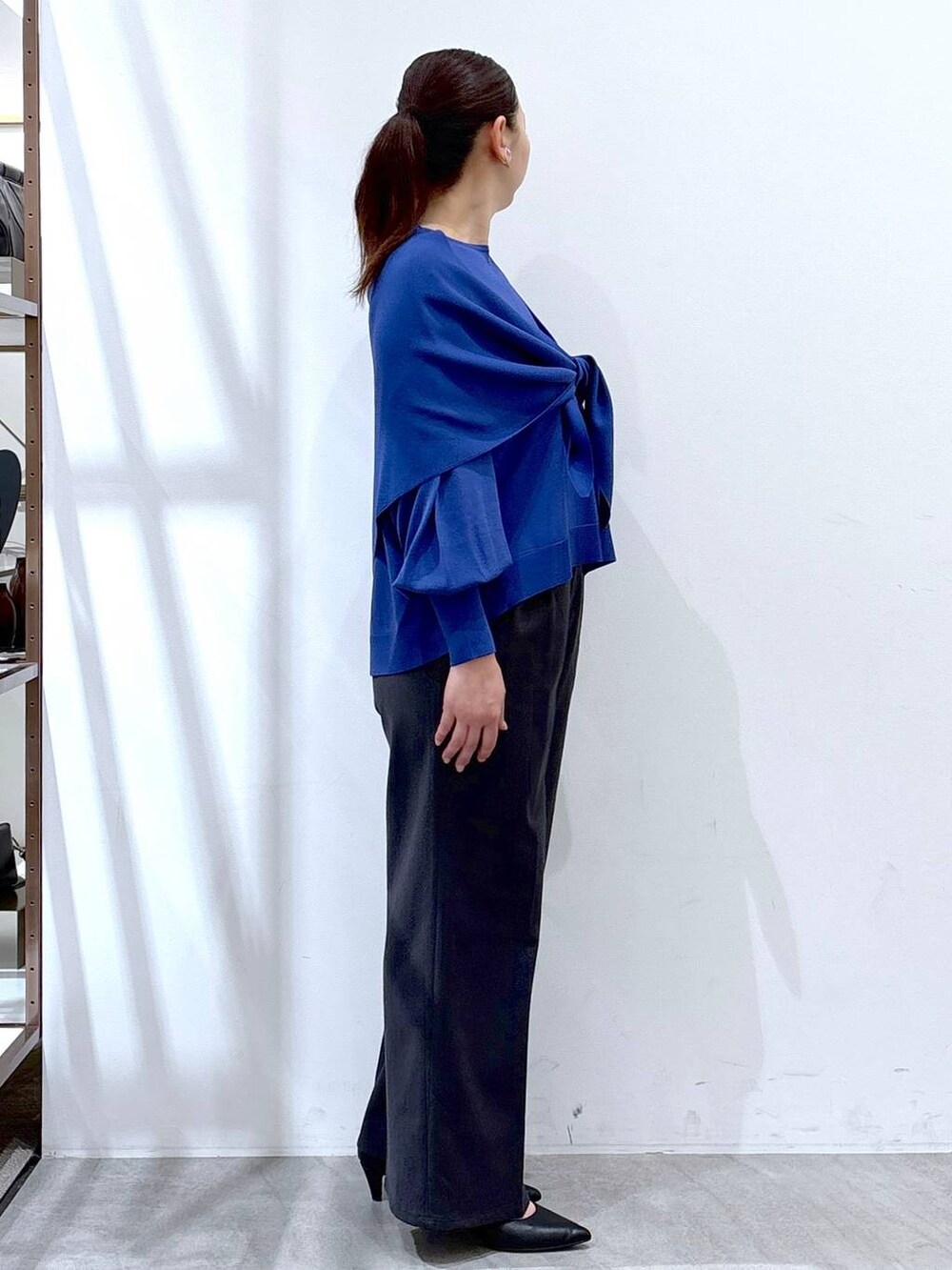 ブルー系のニット/セーター、グレー系のその他パンツ、ブルー系のストール/ショールを着用したレディースの春コーディネートの5枚目の写真