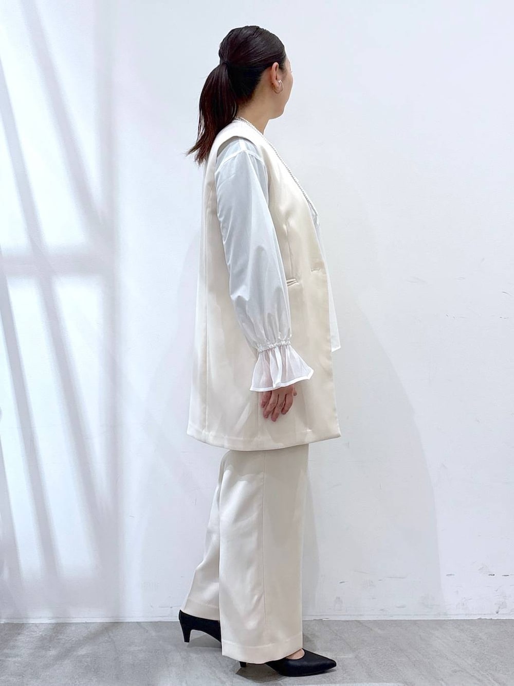 ホワイト系のその他パンツ、ホワイト系のスーツベスト、ホワイト系のシャツ/ブラウスを着用したレディースの冬コーディネートの5枚目の写真