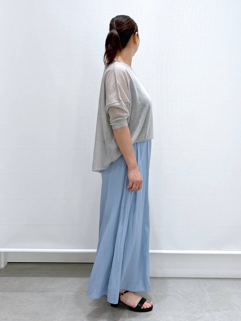 グレー系のニット/セーター、ブルー系のその他パンツ、ブラック系のサンダルを着用したレディースの夏コーディネートの5枚目の写真