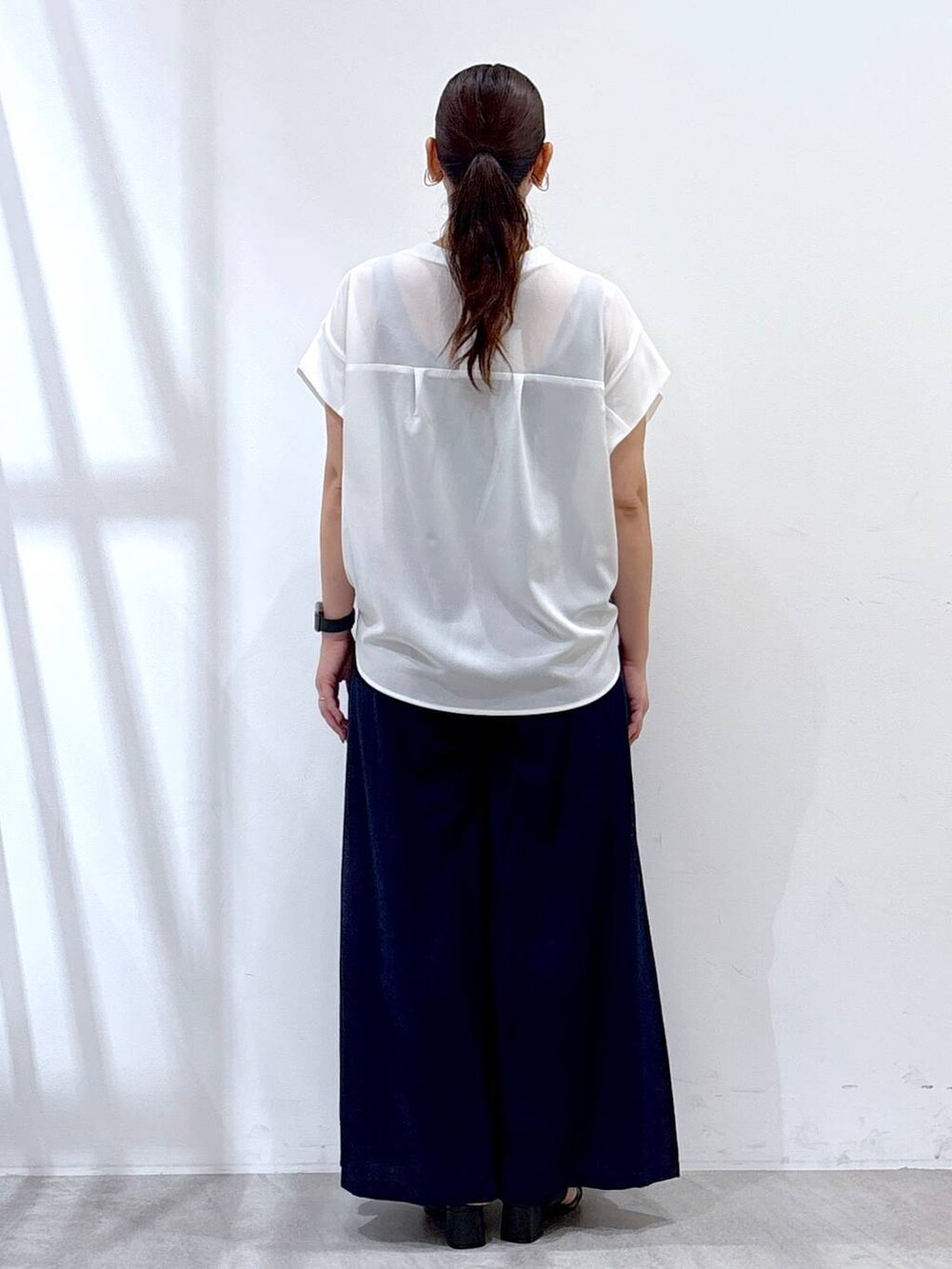 ブルー系のその他パンツ、ブラック系のサンダル、ホワイト系のTシャツ/カットソーを着用したレディースの夏コーディネートの4枚目の写真