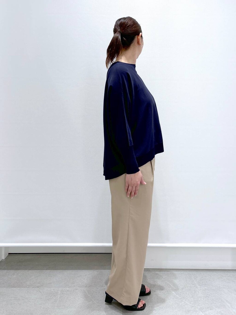 ブラック系のサンダル、ベージュ系のその他パンツ、ブルー系のニット/セーターを着用したレディースの春コーディネートの5枚目の写真