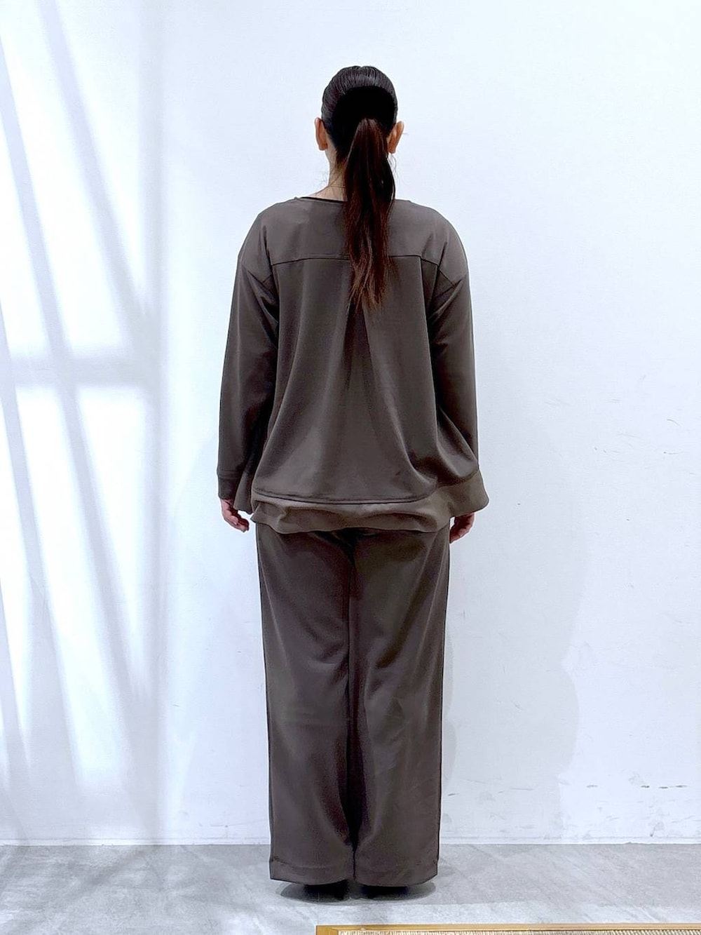 ブラウン系のその他パンツ、ブラウン系のTシャツ/カットソー、ブラック系のハンドバッグを着用したレディースの冬コーディネートの4枚目の写真