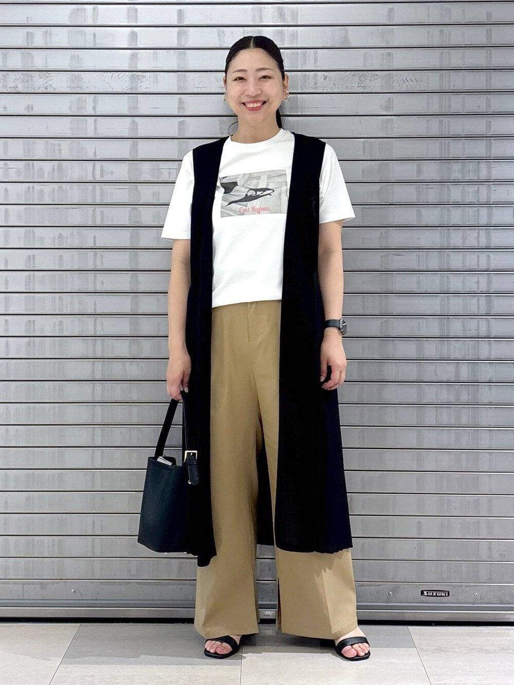 ブラック系のハンドバッグ、ホワイト系のTシャツ/カットソー、ブラウン系のその他パンツを着用したレディースの春コーディネートの2枚目の写真