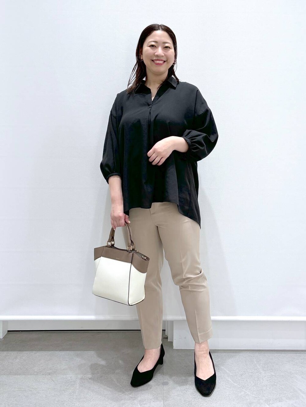 ベージュ系のその他パンツ、ホワイト系のハンドバッグ、ブラック系のパンプスを着用したレディースの春コーディネートの2枚目の写真