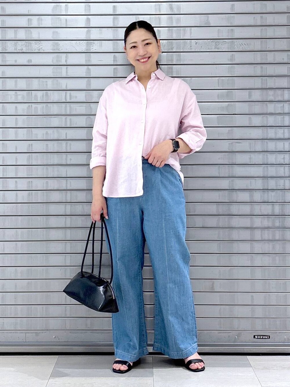 ブラック系のハンドバッグ、ピンク系のシャツ/ブラウスを着用したレディースの春コーディネートの2枚目の写真