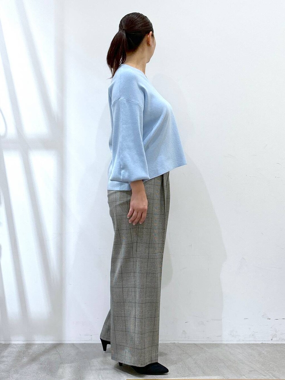 グレー系のその他パンツ、ブラック系のその他パンツ、ブルー系のニット/セーターを着用したレディースの冬コーディネートの5枚目の写真