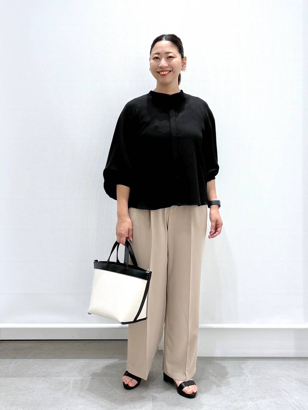 ベージュ系のその他パンツ、ブラック系のサンダル、ブラック系のシャツ/ブラウスを着用したレディースの夏コーディネートの2枚目の写真