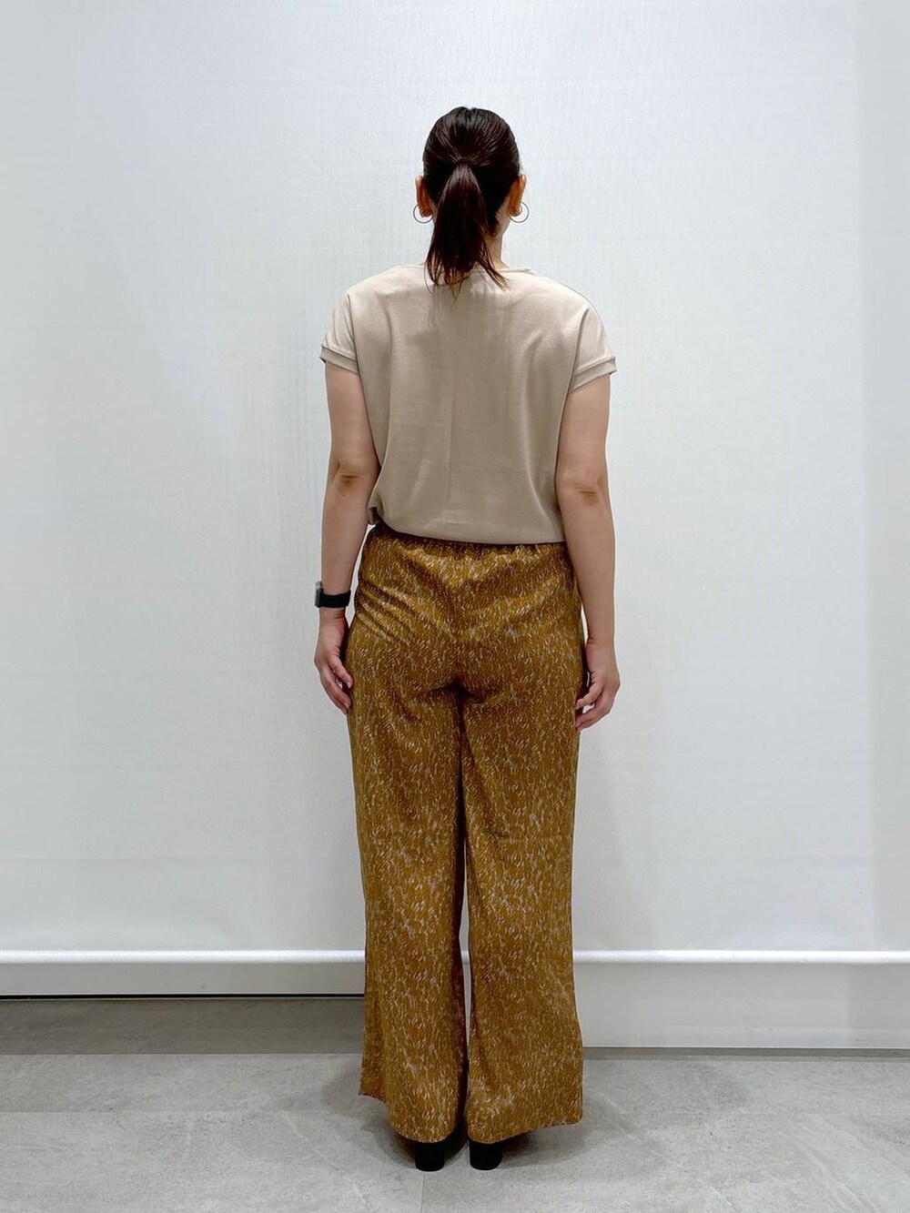 ベージュ系のTシャツ/カットソー、ブラック系のハンドバッグ、ブラウン系のその他パンツを着用したレディースの夏コーディネートの4枚目の写真