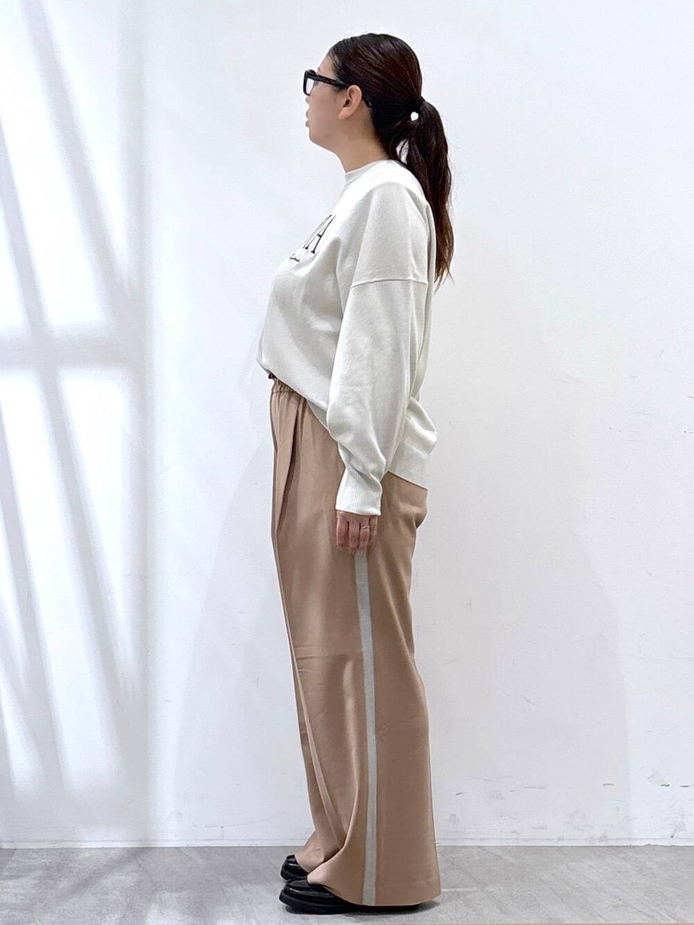 ベージュ系のTシャツ/カットソー、ブラック系のハンドバッグ、ブルー系のテーラードジャケットを着用したレディースの秋コーディネートの2枚目の写真