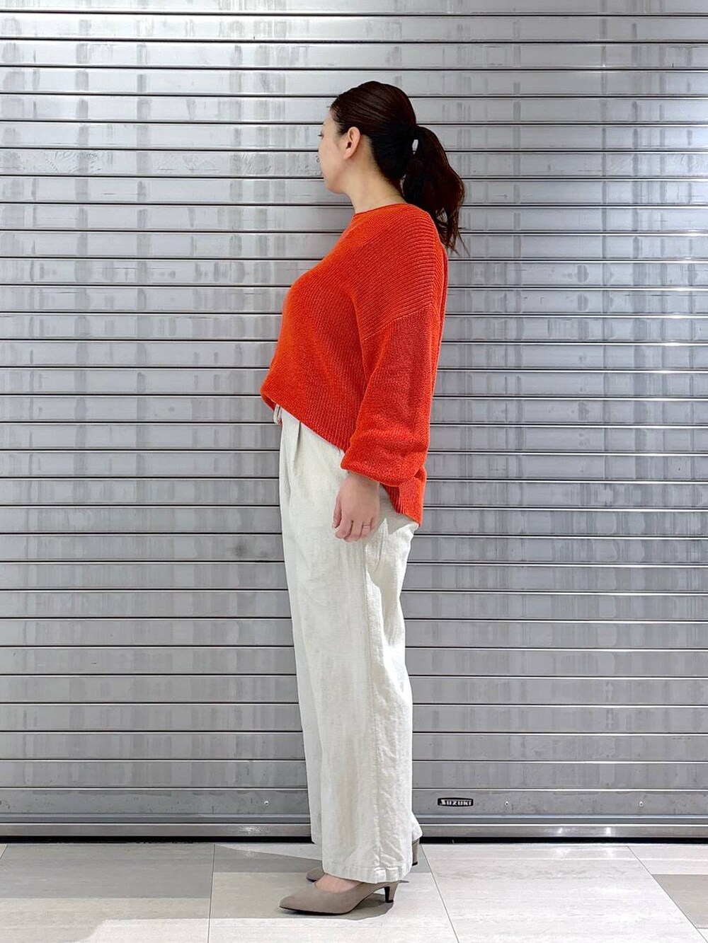 ベージュ系のパンプス、オレンジ系のニット/セーター、ベージュ系のその他パンツを着用したレディースの春コーディネートの3枚目の写真