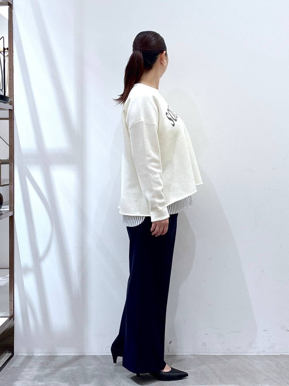 ホワイト系のニット/セーター、ブラック系のタンクトップ、ブルー系のその他パンツを着用したレディースの春コーディネートの5枚目の写真