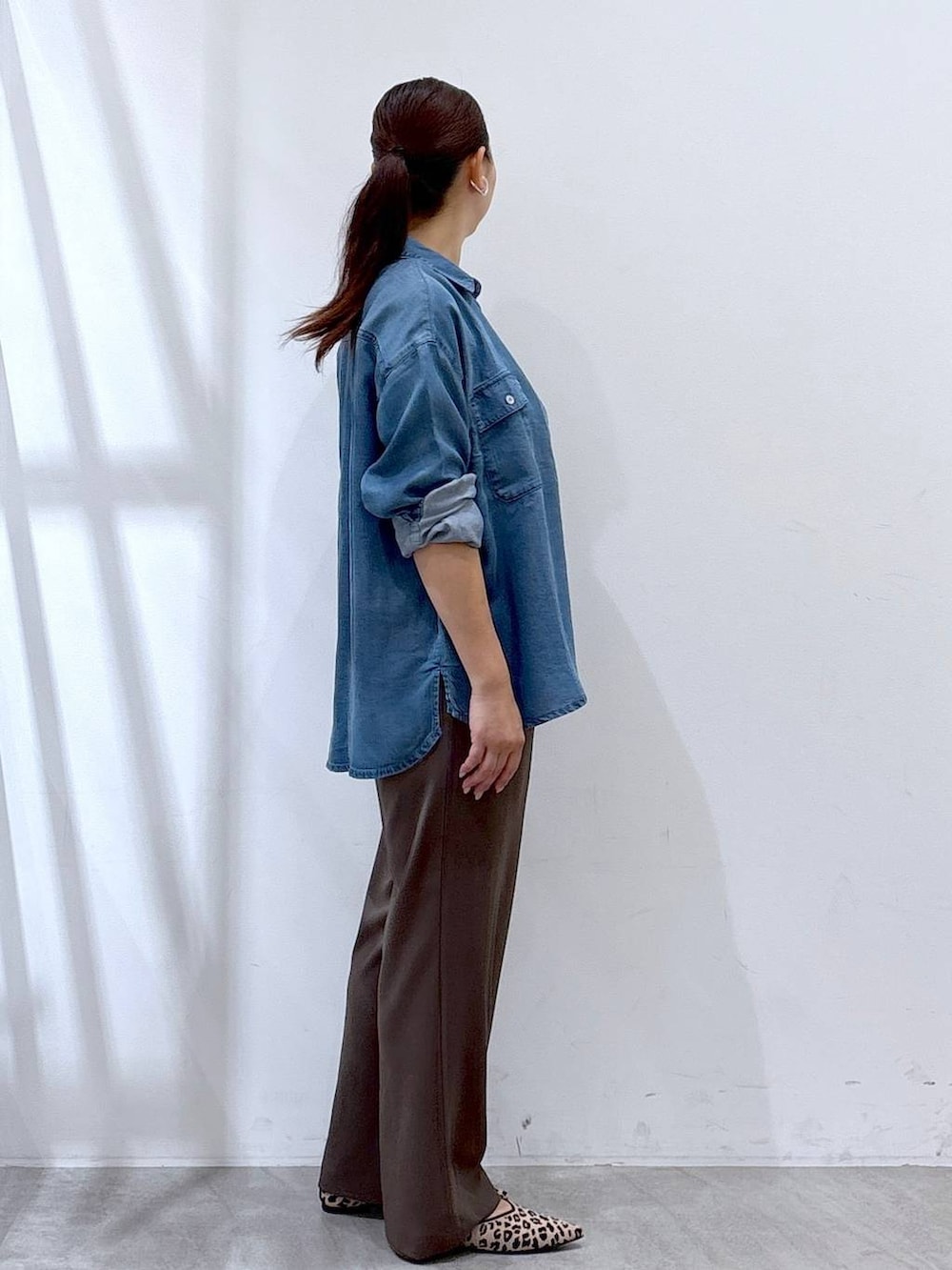 ブラック系のショルダーバッグ、ブルー系のシャツ/ブラウス、ブラウン系のその他パンツを着用したレディースの秋コーディネートの5枚目の写真