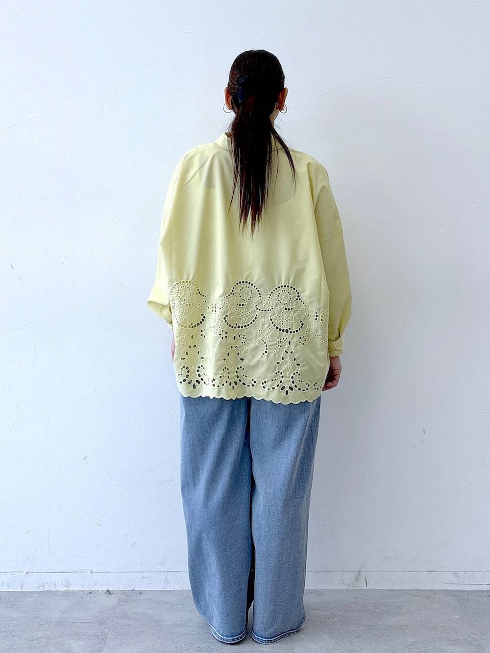 ブラック系のハンドバッグ、ブラック系のパンプス、ブルー系のデニムパンツを着用したレディースの冬コーディネートの4枚目の写真