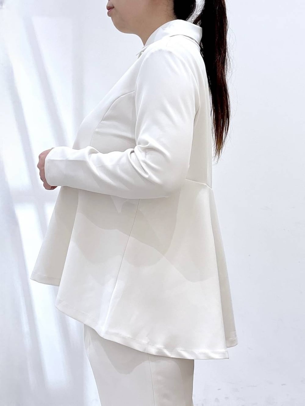 ブラック系のハンドバッグ、ホワイト系のシャツ/ブラウス、ホワイト系のスラックスを着用したレディースの春コーディネートの7枚目の写真