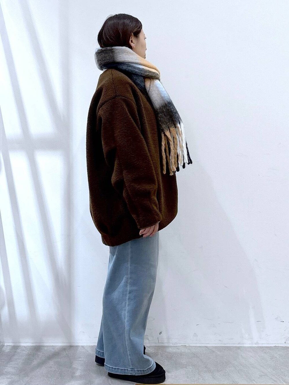 ブラック系のブーツ、ブラック系のボストンバッグ、ブラウン系のブルゾンを着用したレディースの冬コーディネートの5枚目の写真