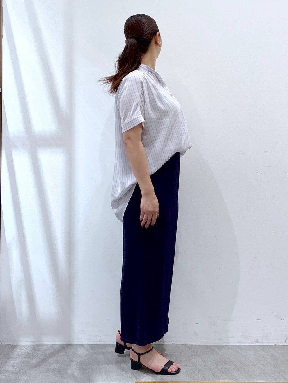 ブルー系のスカート、ブラック系のハンドバッグ、ブルー系のシャツ/ブラウスを着用したレディースの夏コーディネートの5枚目の写真