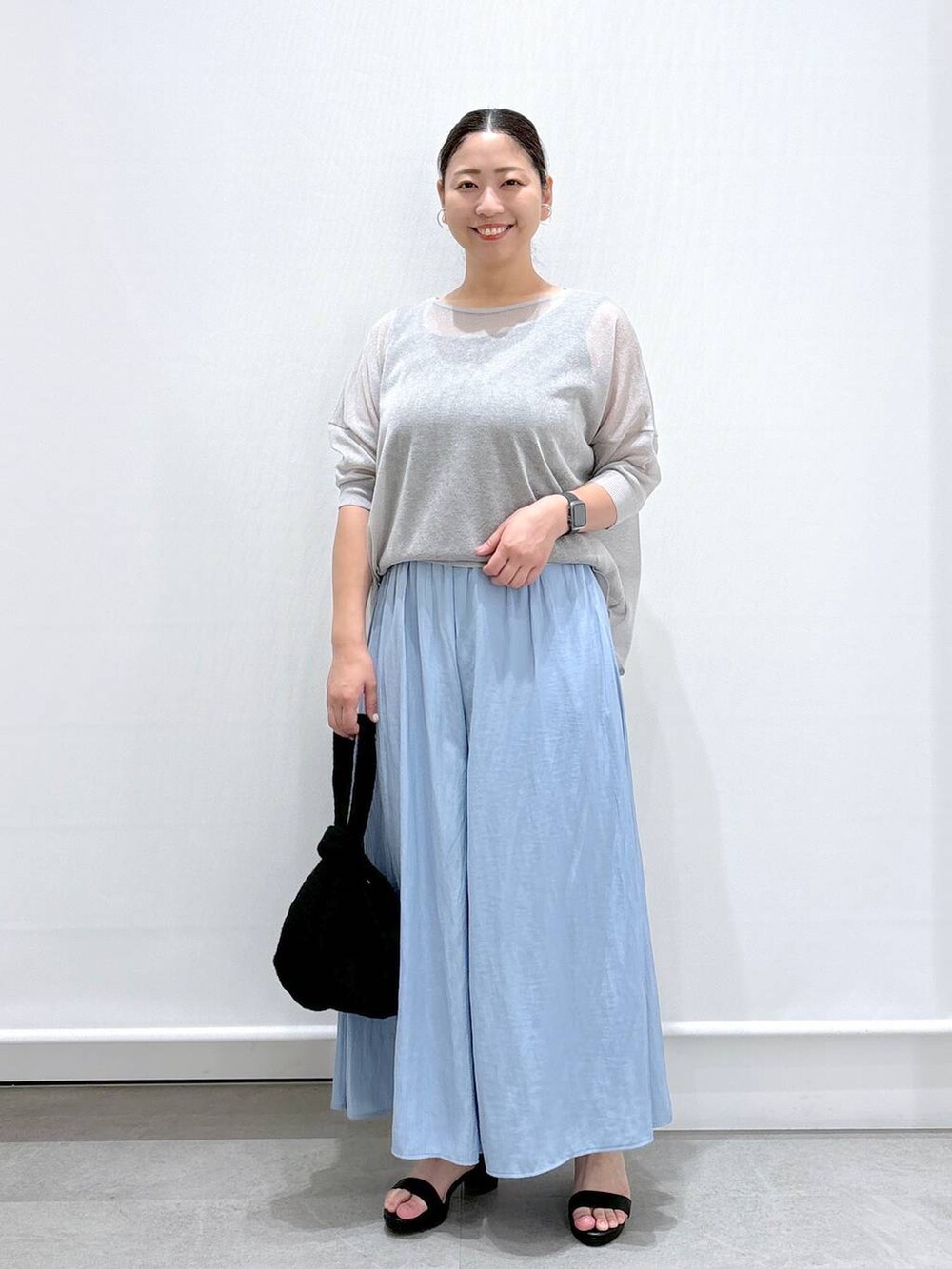 グレー系のニット/セーター、ブルー系のその他パンツ、ブラック系のサンダルを着用したレディースの夏コーディネートの2枚目の写真